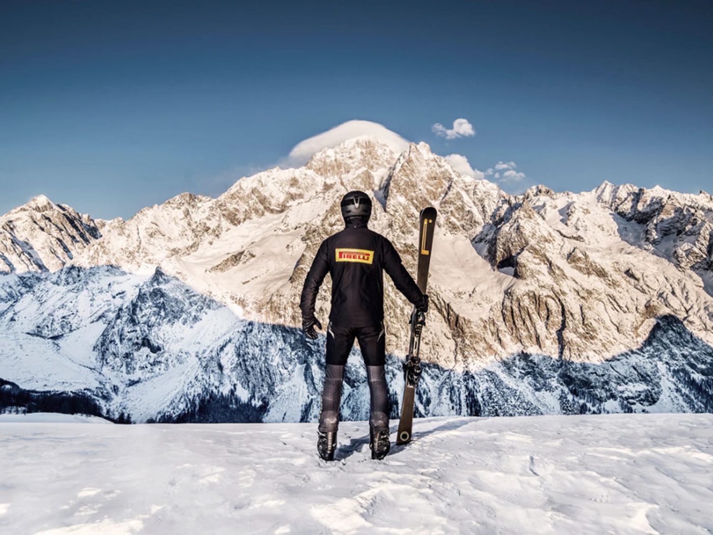 Skifahrer mit PIRELLI vor Bergpanorama