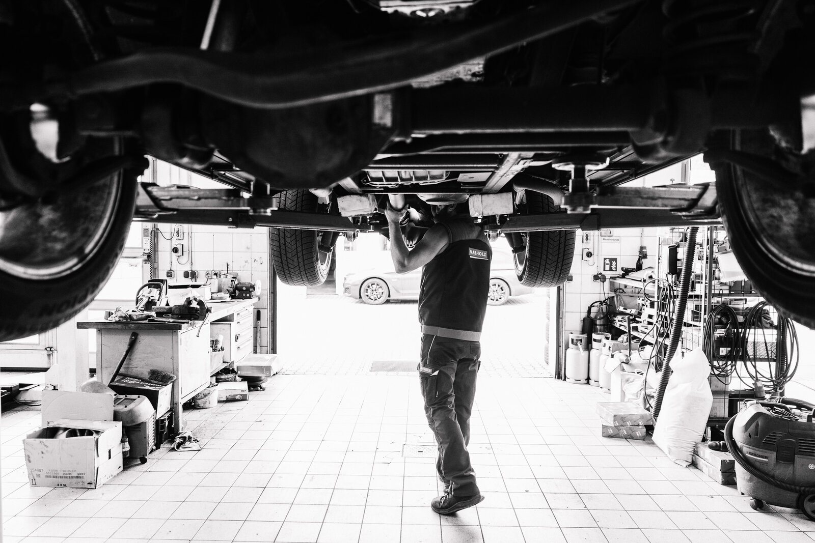 Arbeit unter dem Fahrzeug, Schwarzweißaufnahme