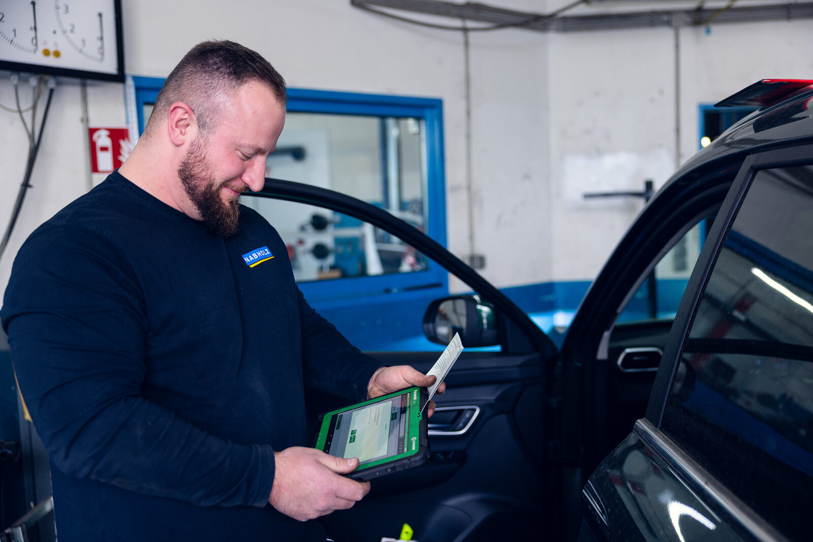 Mechatroniker mit Tablet an einem Fahrzeug